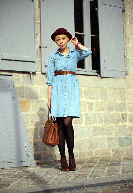 Модный лук: голубое джинсовое платье-рубашка выше колен, черные плотные колготки, кожаный ремень, коричневая кожаная сумка, коричневые лакированные ботинки и бордовая фетровая шляпа