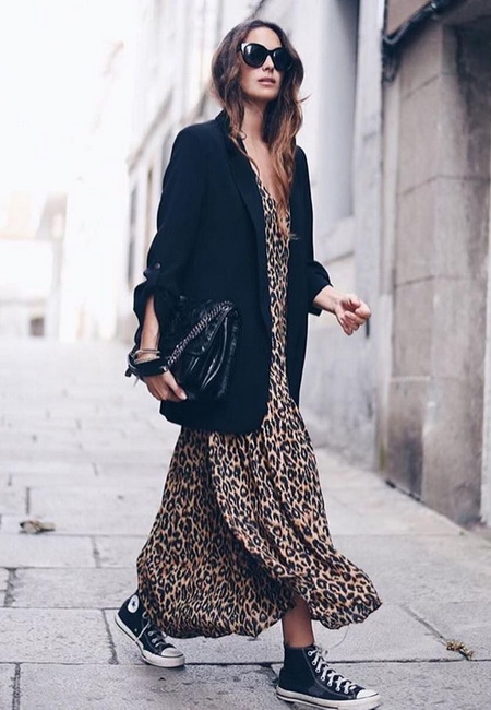 Модный лук: длинное леопардовое свободное платье, удлиненный черный пиджак, большая черная кожаная сумка, черные кеды, темные очки и золотые браслеты