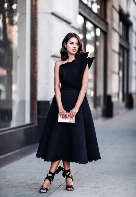Модный лук: стильное маленькое черное вечернее платье-миди с изящным воротом, черные босоножки с завязками вокруг ноги, маленький серебряный клатч и длинные серьги