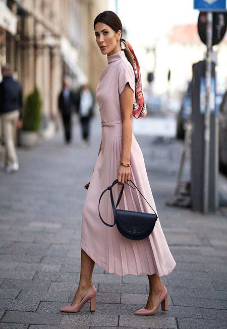 Модный лук: Пудровое платье с поясом и короткими рукавами, с юбкой плиссе, кожаные туфли-лодочки на высоком каблуке, черная сумка сэдл, шелковый платок с принтом, металлический браслет