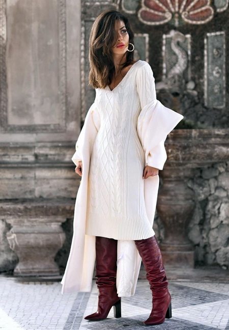 Модный лук: теплое белое вязанное платье длины миди, высокие коричневые кожаные сапоги на каблуке, белое пальто и серьги-кольца