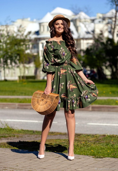 Модный лук: зеленое шифоновое платье с оборками и открытыми плечами, белые туфли-лодочки, коричневая шляпа-федора и соломенная полукруглая сумочка