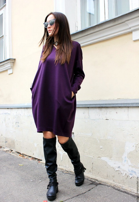 Модный лук: свободное фиолетовое платье-тюльпан длины миди с карманами, высокие черные кожаные сапоги на небольшом каблуке, солнцезащитные очки и ожерелье с камнем