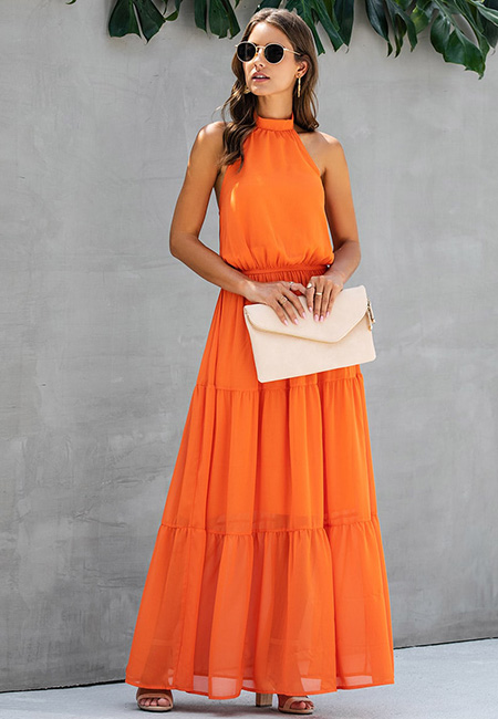Модный лук: Длинное ярусное оранжевое платье с вырезом халтер и нюдовые лаковые босоножки на каблуке, кожаная сумка-конверт, тонкие золотые кольца, круглые позолоченные серьги, солнцезащитные очки