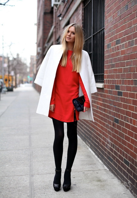 Модный лук: красное прямое платье-мини, черные плотные колготки, черные кожаные босоножки с ремешком на щиколотке, черный кожаный клатч с подвеской и белое прямое оверсайз пальто