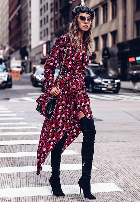 Модный лук: красное платье в цветочек с запахом и ассиметричным подолом, черные замшевые ботфорты на шпильке, черный кожаный берет, маленькая черная сумочка на длинной цепочке и большие солнцезащитные очки