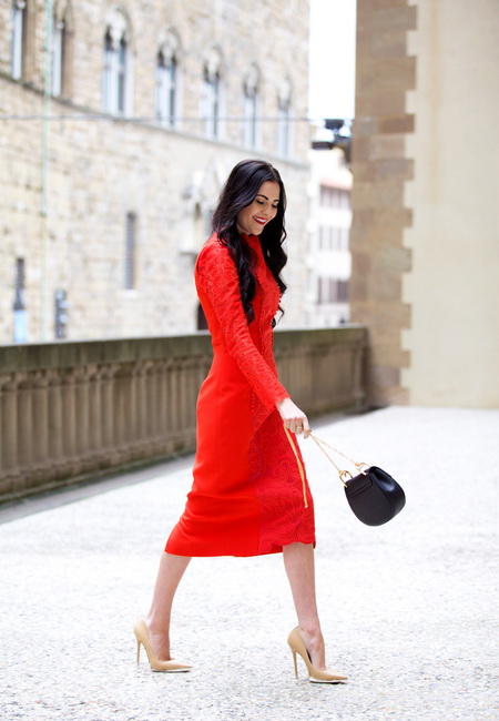 Модный лук: красное строгое платье длины миди с длинными рукавами, бежевые лаковые туфли на шпильке и маленькая черная полукруглая сумочка из кожи на цепочке 