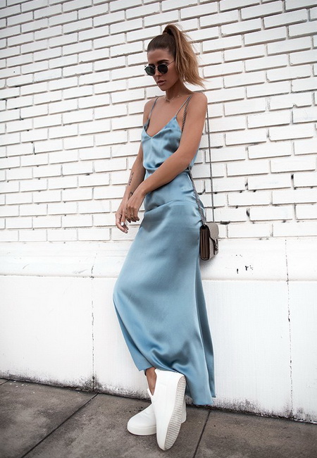 Модный лук: длинное голубое платье-комбинация на бретелях, белые кроссовки, маленькая серая кожаная сумочка на цепочке и темные солнцезащитные очки
