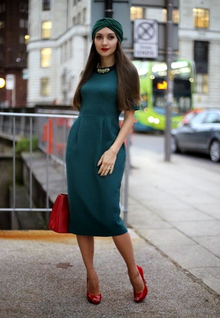 Модный лук: зеленое платье-колокол миди, красные кожаные туфли на шпильке с открытым носком, небольшая красная кожаная сумка, зеленая широкая чалма и ожерелье